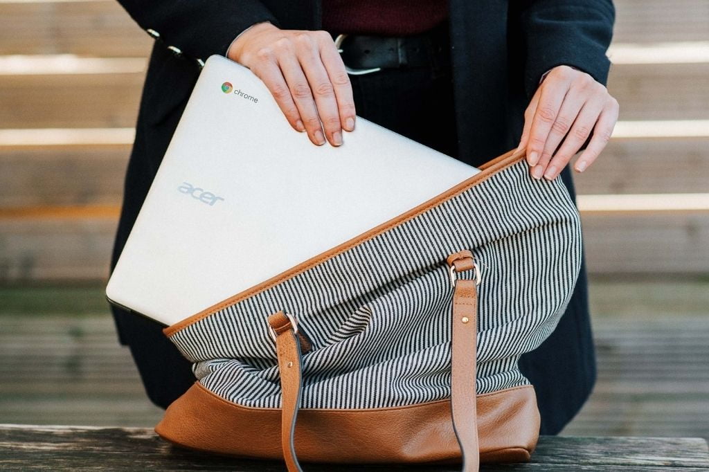 image of a woman putting a Chromebook into her purse
