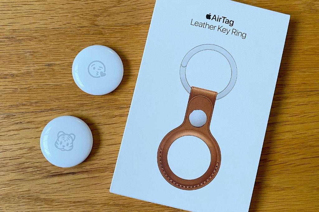 two AirTags and a leather AirTag key ring