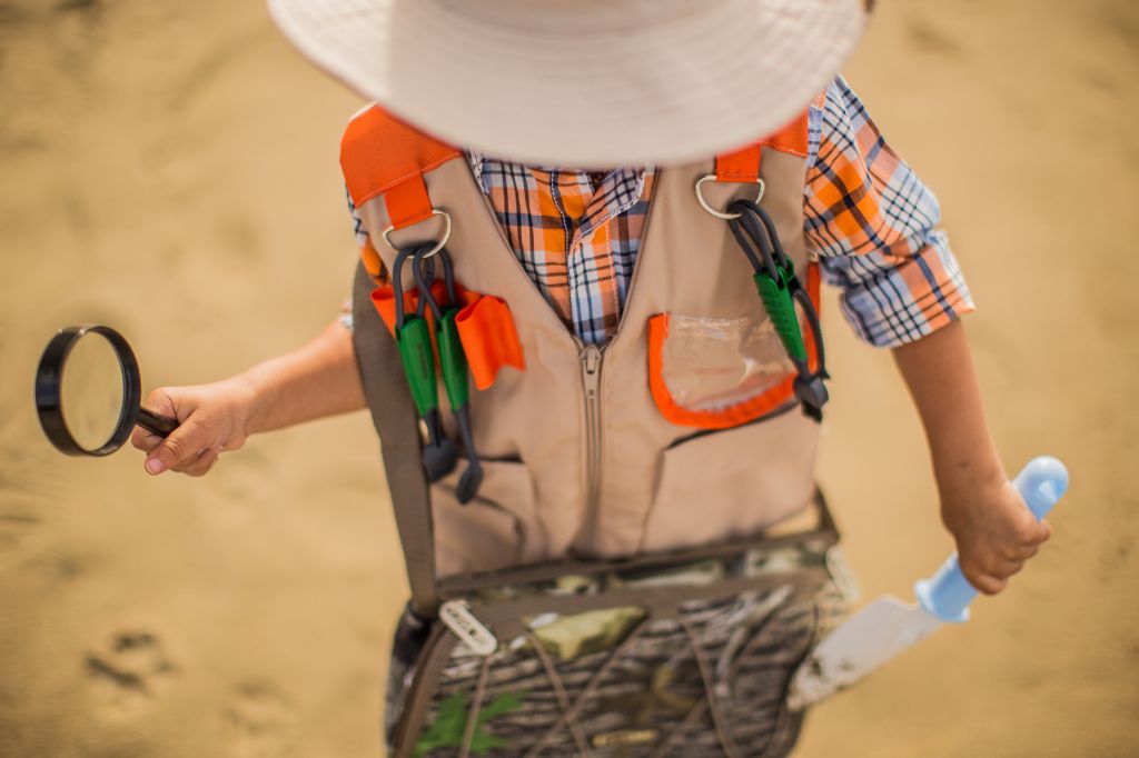 image of a kid wearing an explorers outfit carrying a magnifying glass