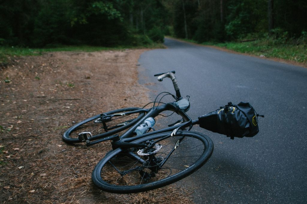 image of a stolen bicycle laid on the side of the road within a wooded area